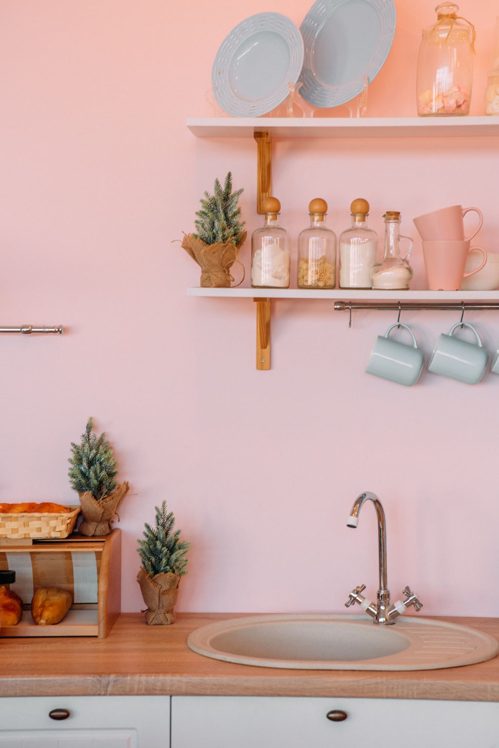 Pastel pink kitchen. Sink and shelves.