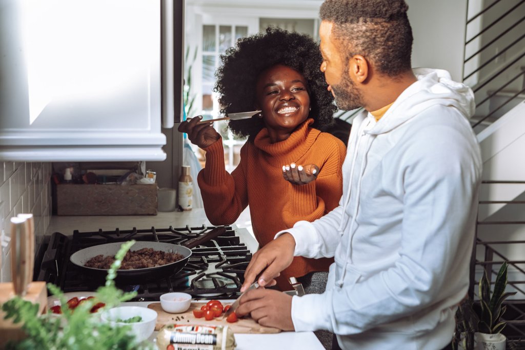Happy young couple cooking together in modern kitchen. Image from UnSplash.